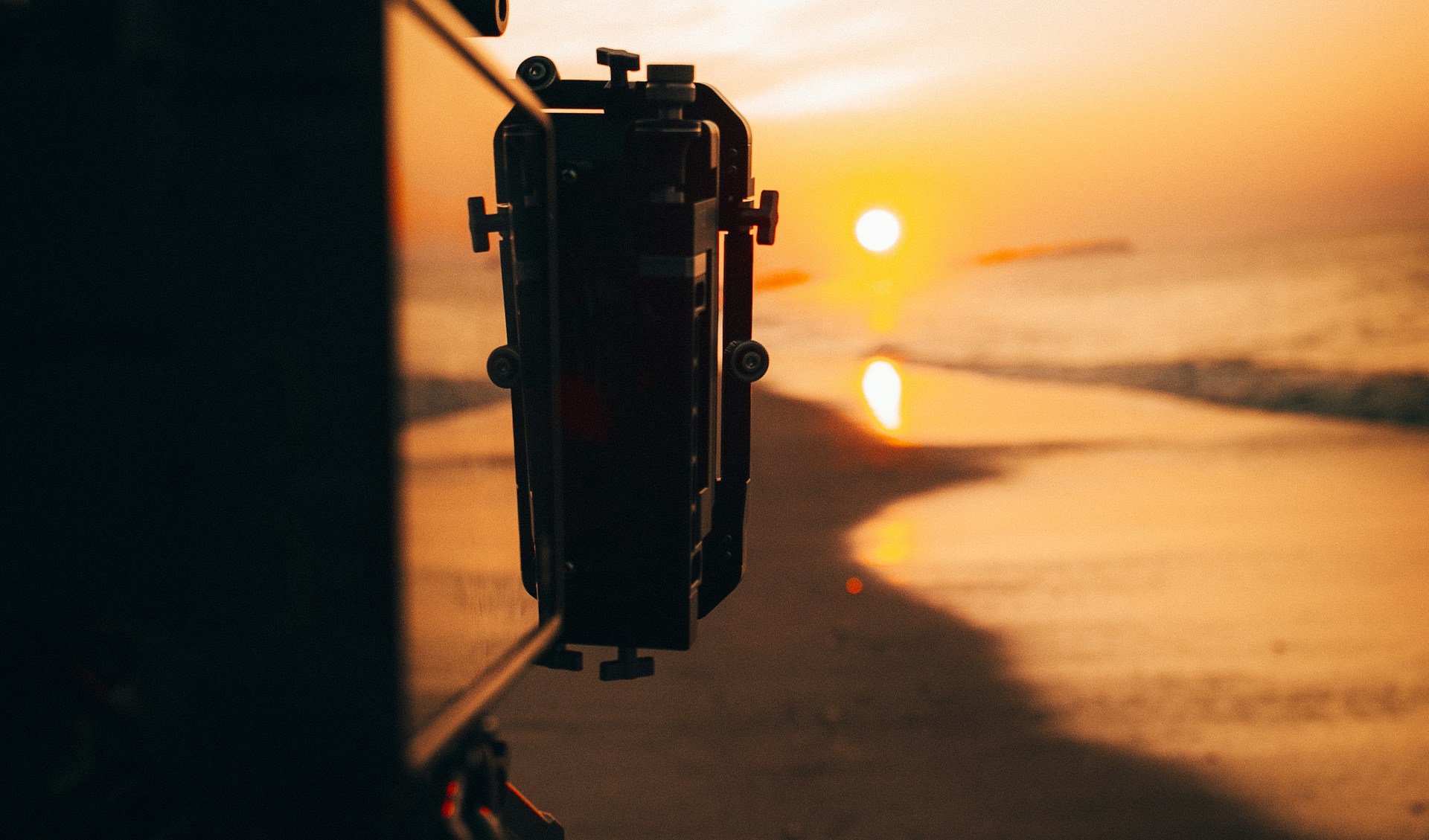 Cinematographer holding camera at golden hour on the beach