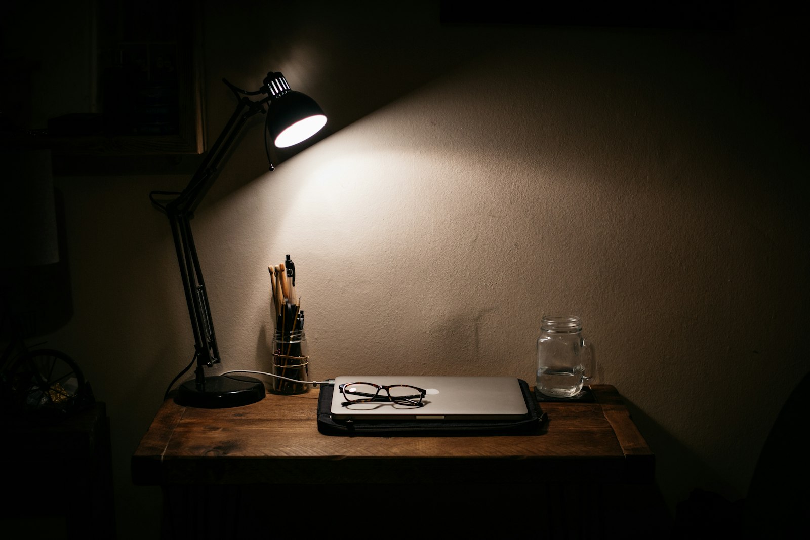 A desk lamp lighting tools on a table — the unglamorous admin work